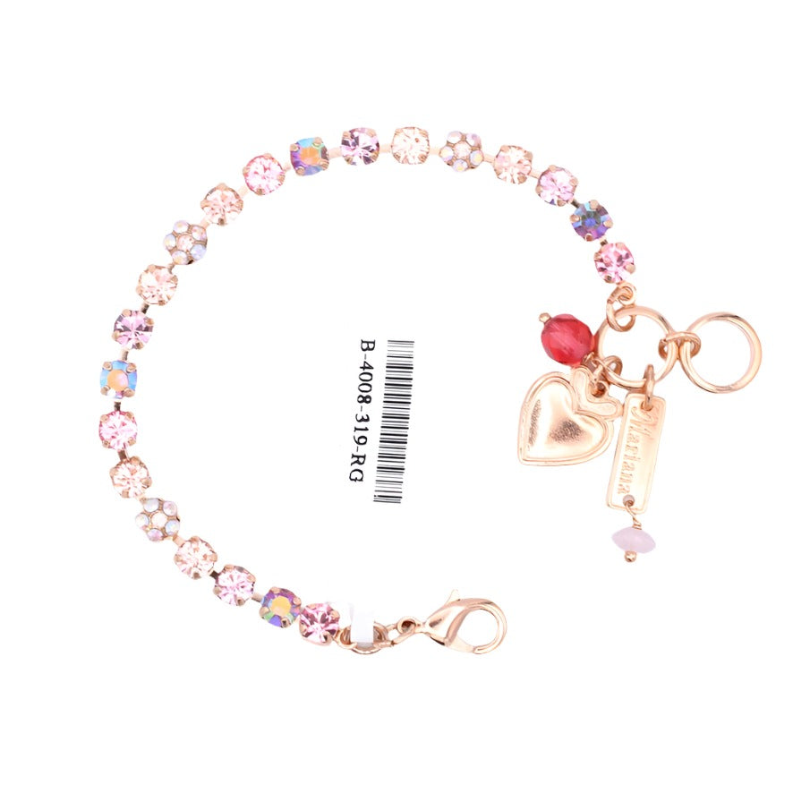 A rose gold-colored bracelet with a floral design, featuring small crystals and a heart-shaped charm, displayed on a tag with a barcode.