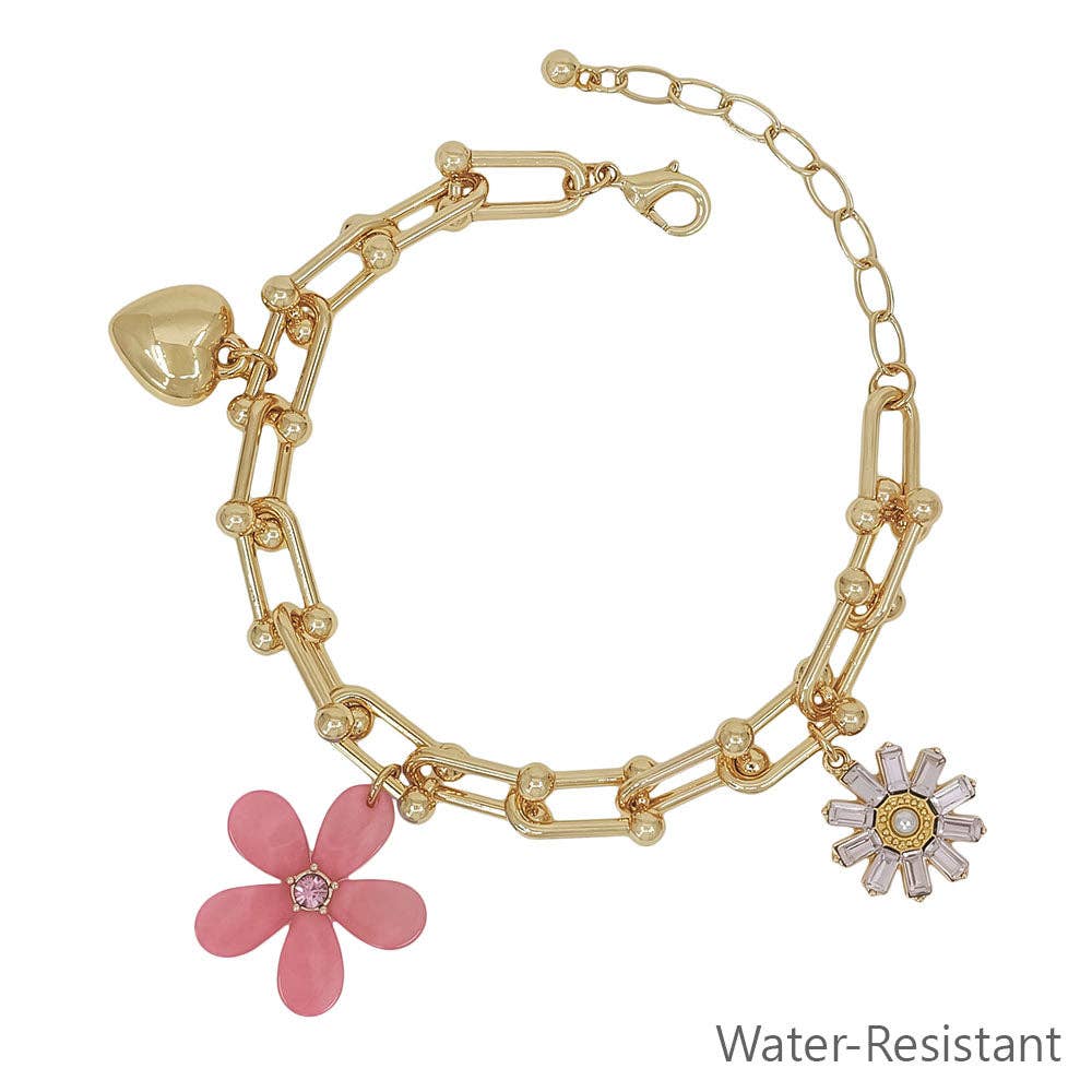Gold bracelet with pink flower charm on a white background