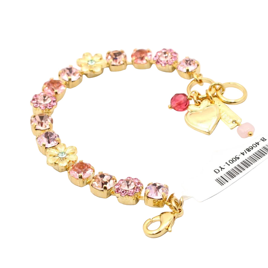 Gold bracelet with pink gemstones and charms on a white background