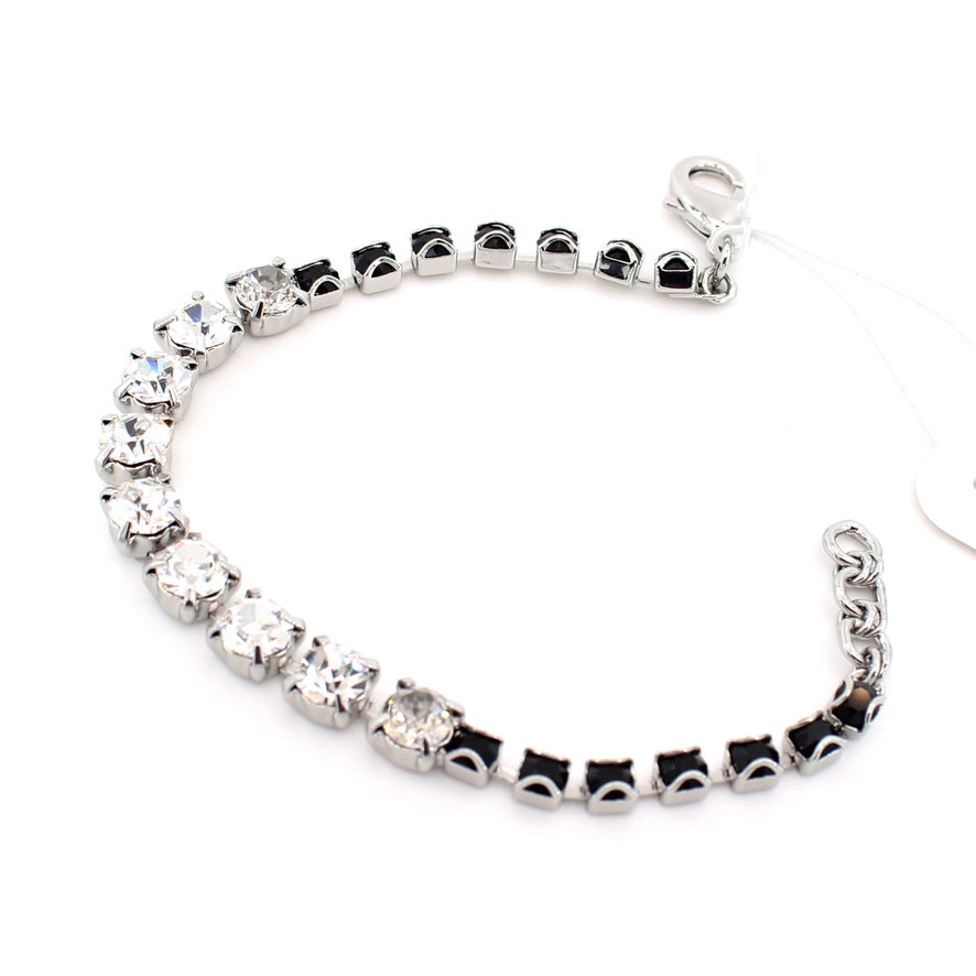 Silver bracelet with clear gemstones on a white background