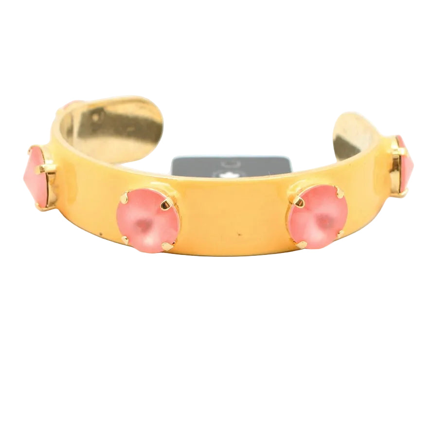 Gold bracelet with pink stones on a white background