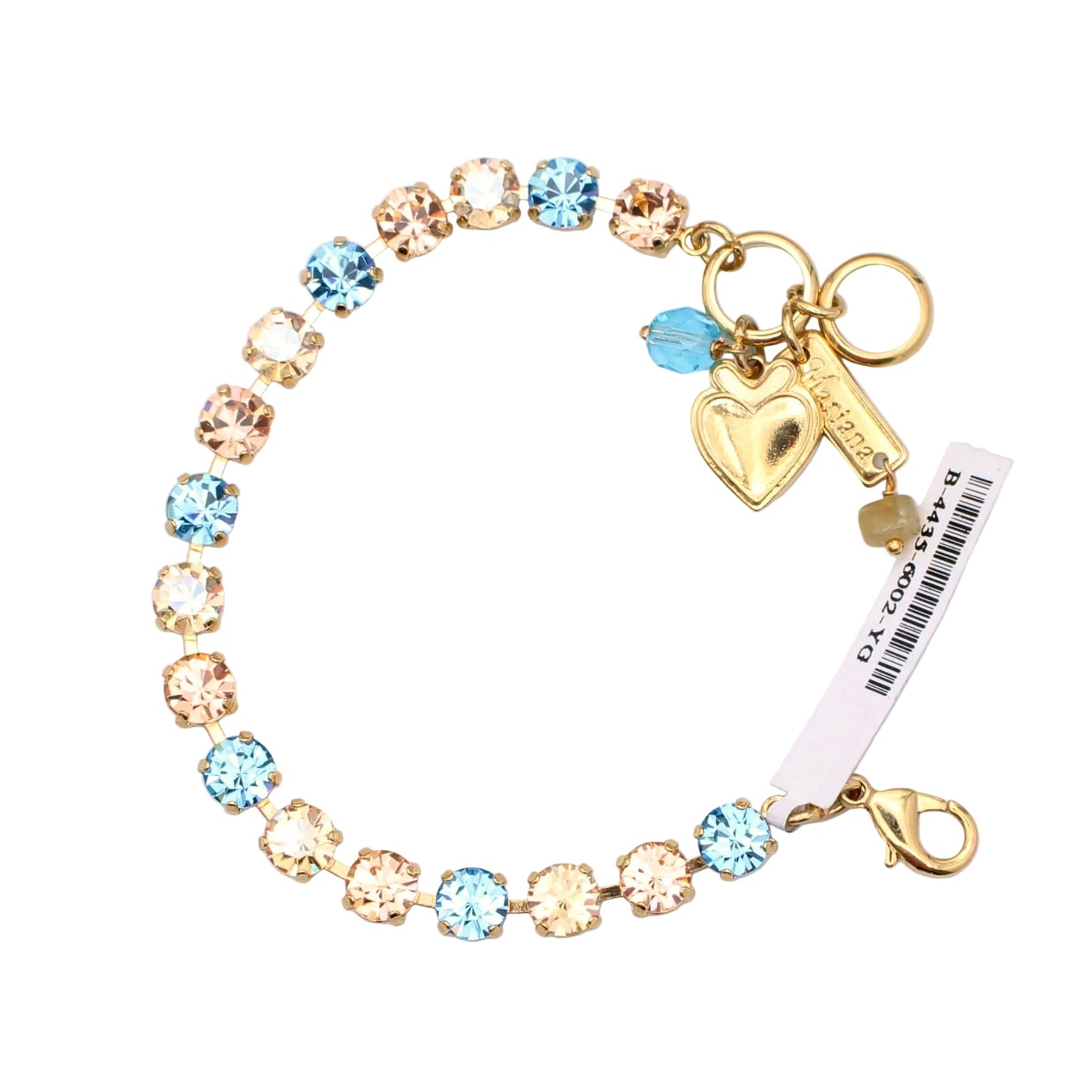Gold bracelet with blue and clear gemstones and heart charm on a light purple background
