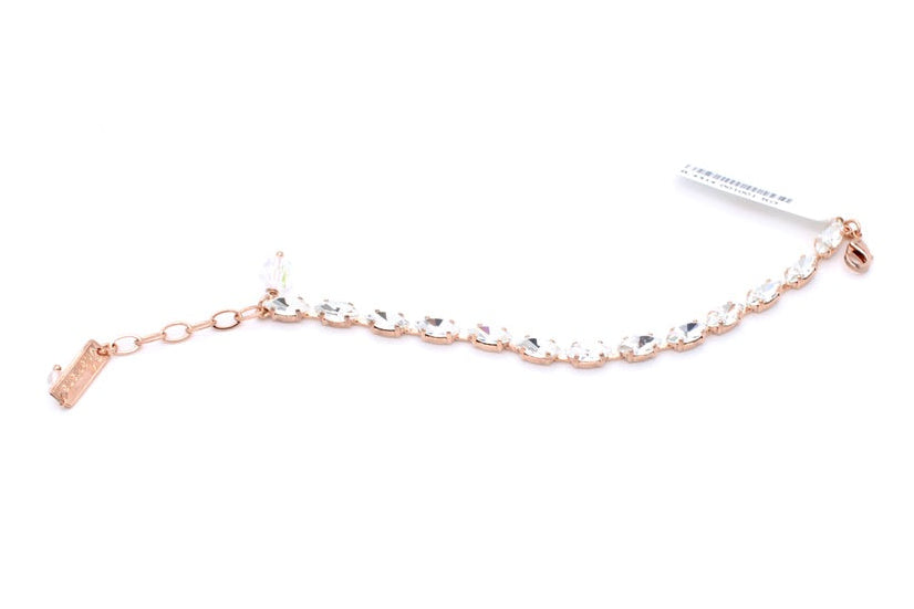 A delicate rose gold chain bracelet adorned with clear rhinestones, featuring an adjustable lobster clasp and a small branded tag attached, set against a plain white background.