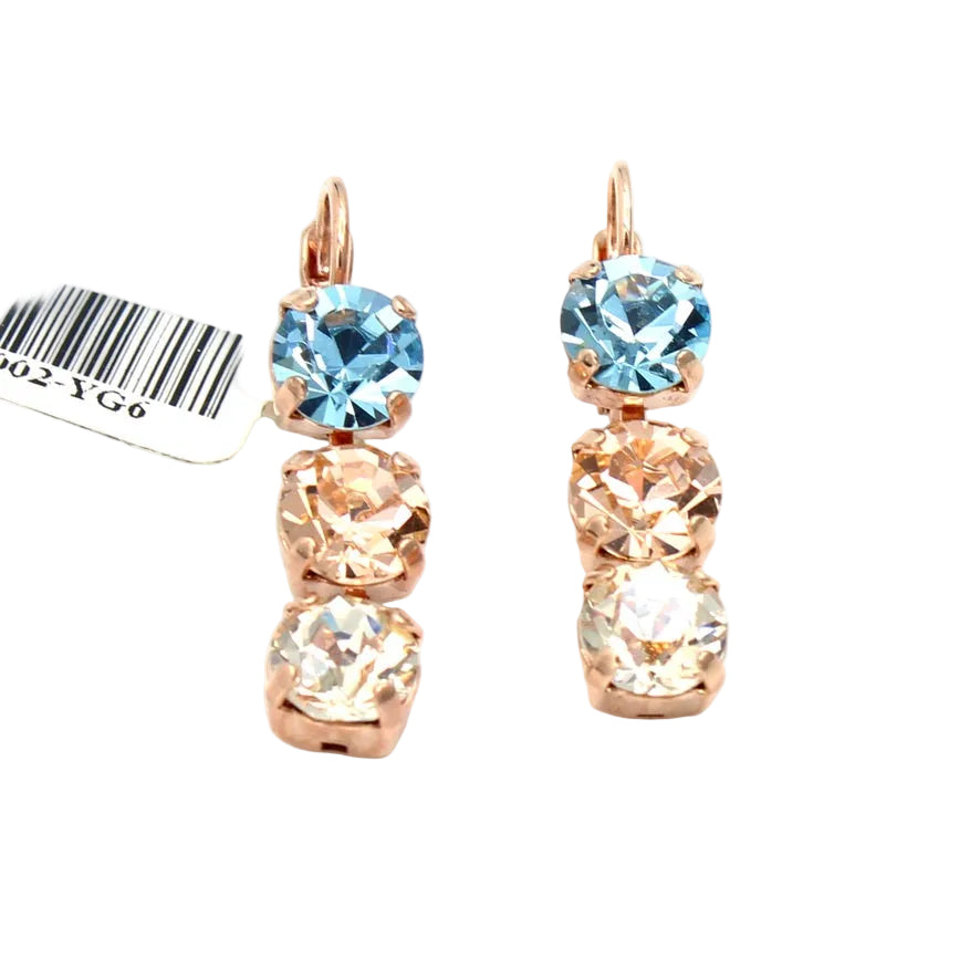 Pair of rose gold earrings with blue and clear gemstones on a white background.