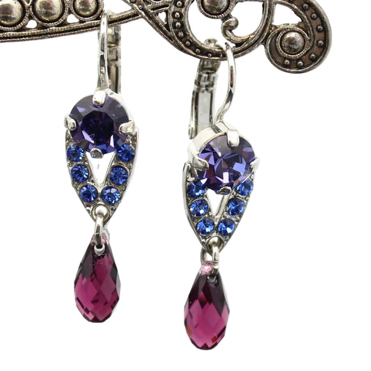 Pair of earrings with purple and blue gemstones on a white background