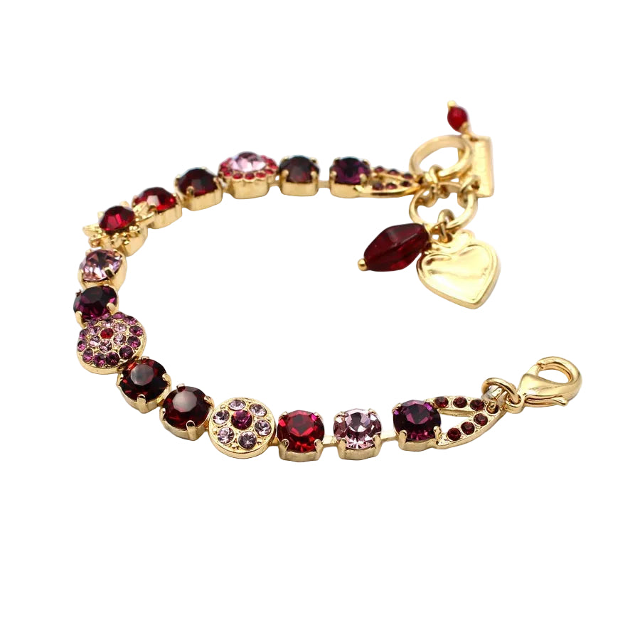 Gold bracelet with red 
gemstones and a heart charm on a white background