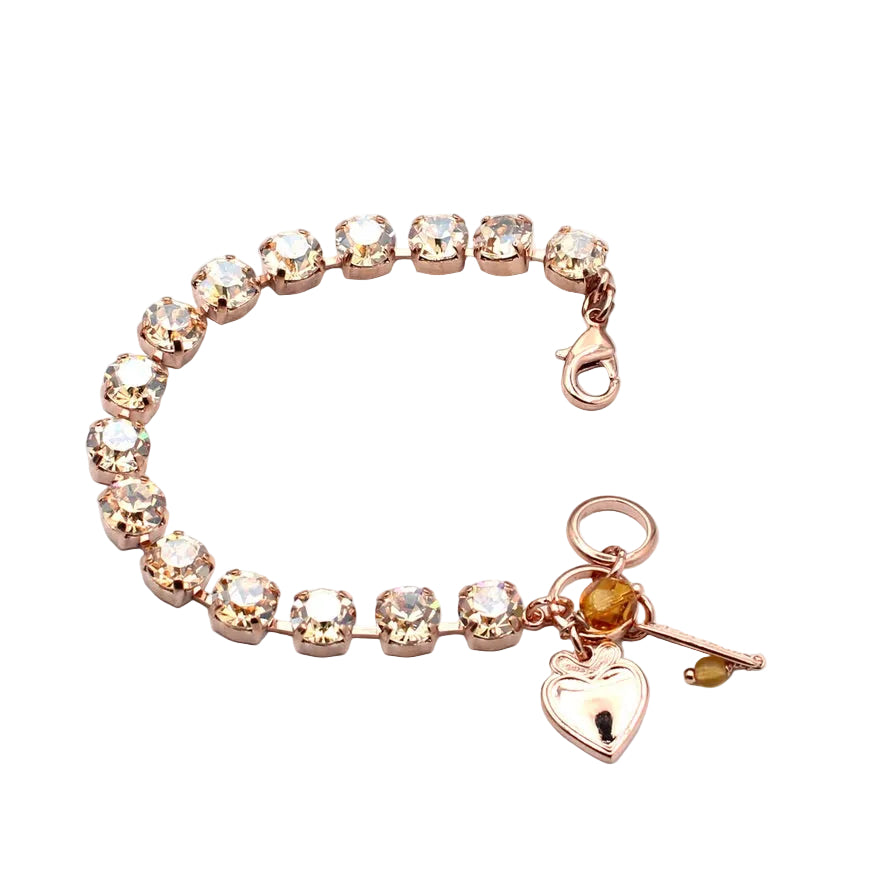 Rose gold bracelet with heart charm on a white background