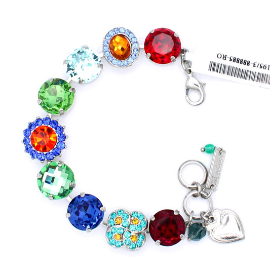A silver charm bracelet featuring a series of colorful round and floral rhinestone beads in red, blue, green, orange, and light blue, with a heart-shaped charm and a small tag attached.