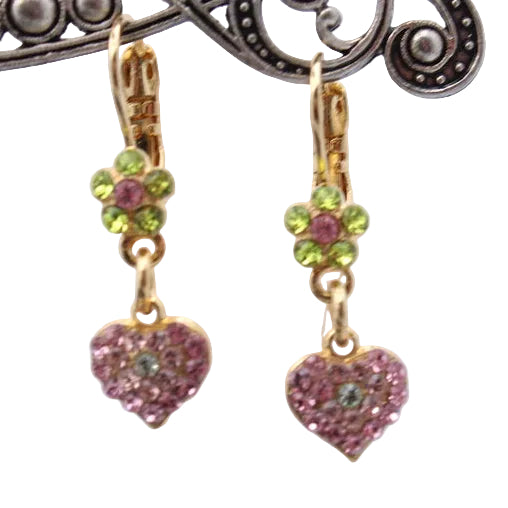 Heart-shaped earrings with green and pink stones on a decorative stand.