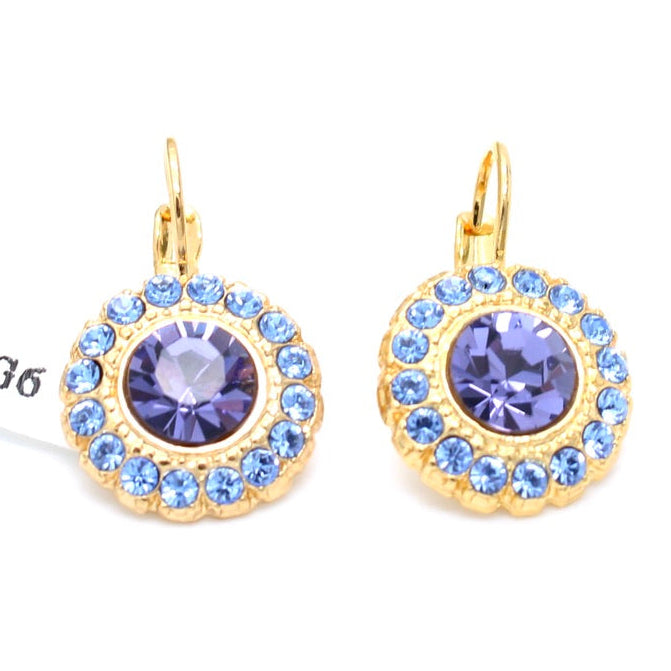 A pair of gold-tone drop earrings with a halo of light blue rhinestones surrounding a central purple crystal, shown on a white background.