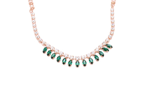 A rose gold necklace featuring a curved row of marquise-cut green emeralds accented by small clear stones, displayed on a clean white background.