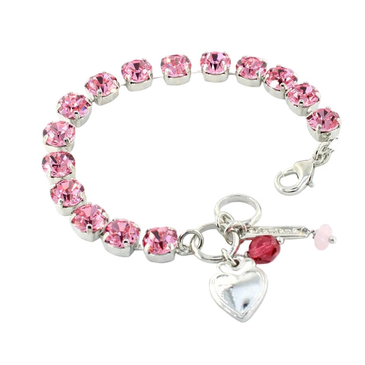 Pink crystal bracelet with a heart charm on a white background